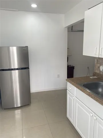 a kitchen with a refrigerator and a sink
