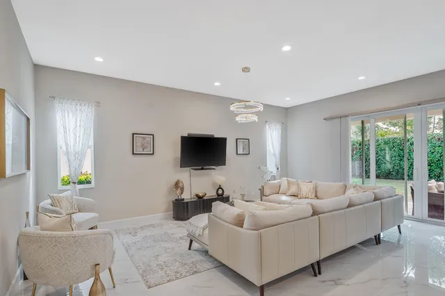 a living room with furniture and a view of kitchen