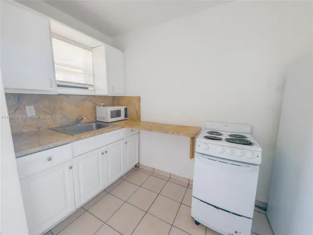 a kitchen with a stove top oven sink and cabinets