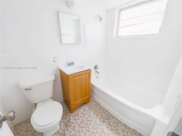 a white toilet sitting next to a bath tub