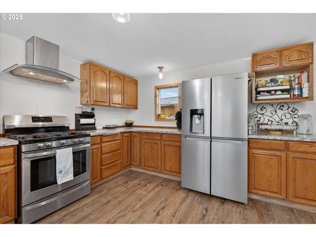 a kitchen with stainless steel appliances granite countertop a refrigerator stove and sink