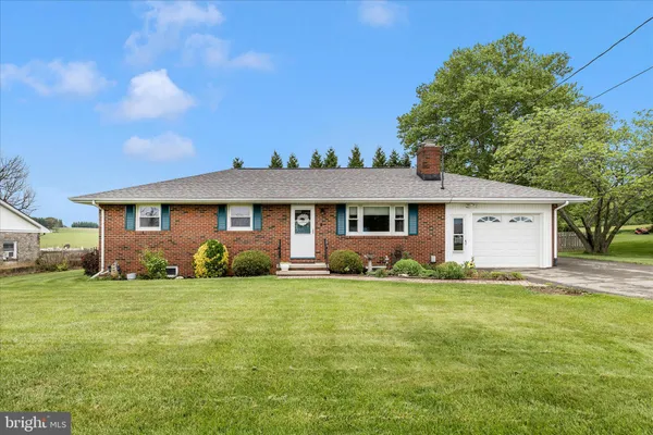 a view of a house with a big yard and large trees