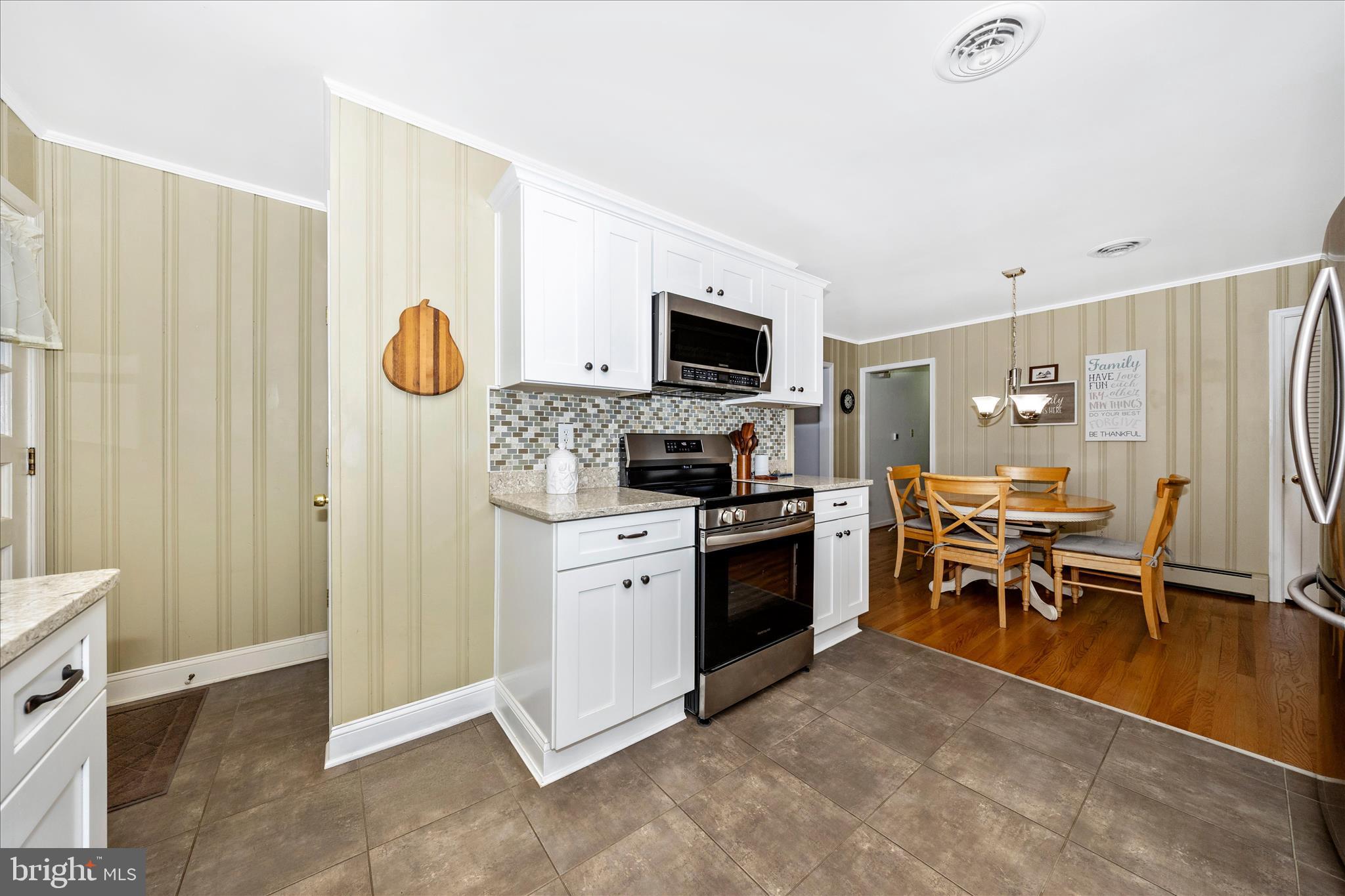 4432 Valley View Road Middletown, MD 21769 - Photo 11 of 54 a kitchen with stainless steel appliances granite countertop a stove top oven a sink dishwasher a dining table and chairs with wooden floor