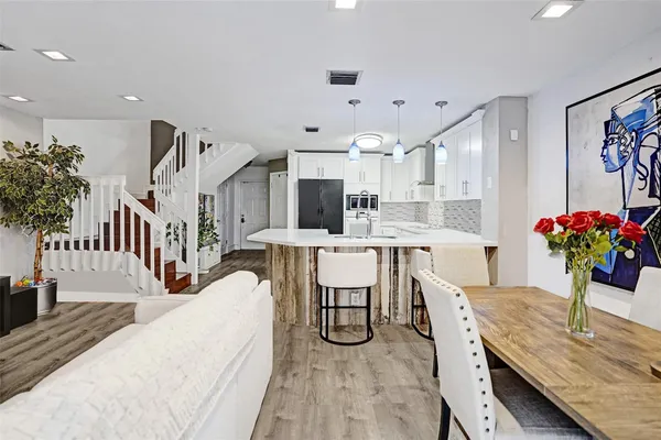 a living room with furniture kitchen view and a large window