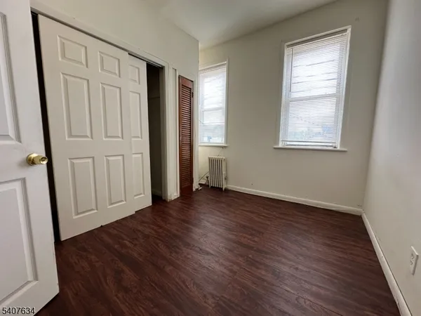 an empty room with wooden floor and window