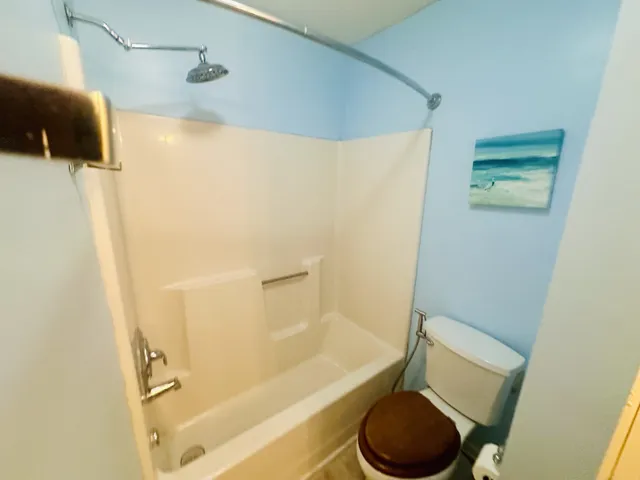 a bathroom with a toilet and a shower