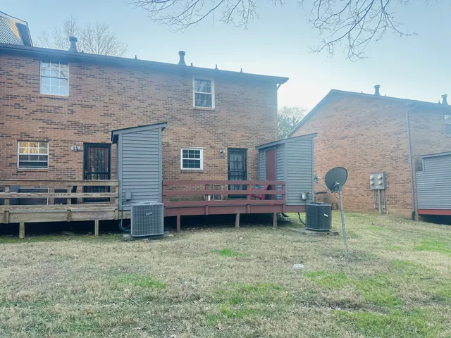 a backyard of a house with barbeque oven and chairs
