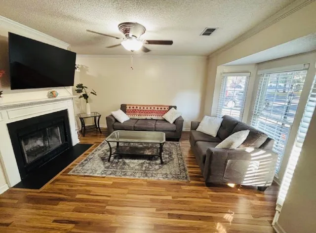 a living room with furniture a fireplace and a flat screen tv