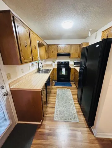 a kitchen with sink refrigerator and microwave