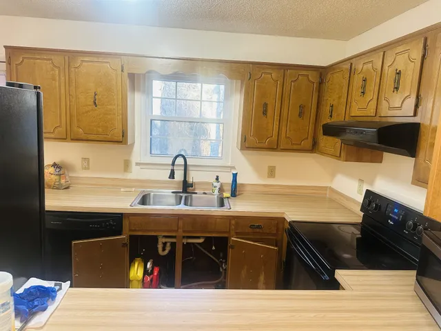 a kitchen with stainless steel appliances granite countertop a sink stove and cabinets