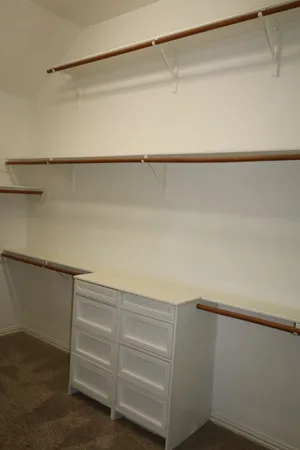 a view of walk in closet with empty racks