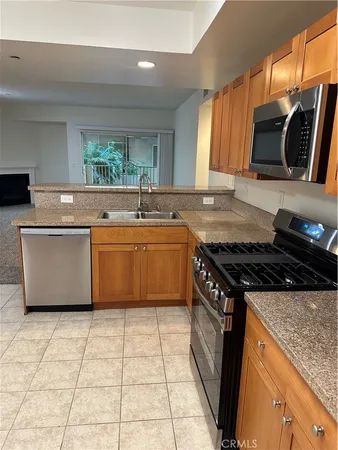 a kitchen with stainless steel appliances granite countertop a sink a stove top oven a counter space and cabinets