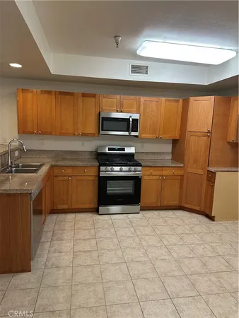 a kitchen with a sink a stove top oven and cabinets