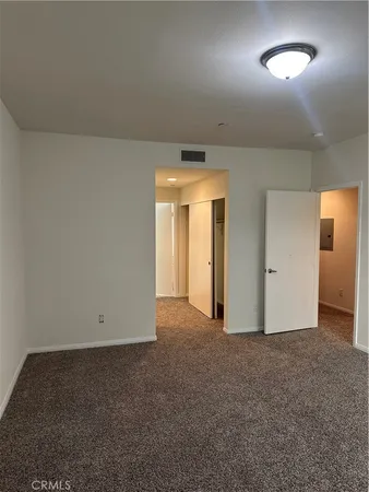 an empty room with closet and mirror