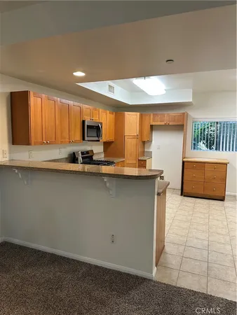 a kitchen with granite countertop a stove a sink and a microwave