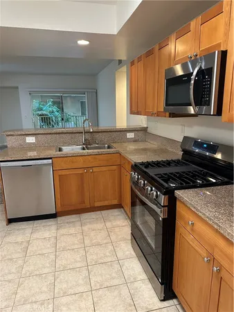 a kitchen with stainless steel appliances granite countertop a stove a sink and a microwave