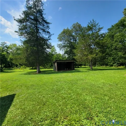 a view of green field with trees in the background