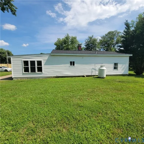 a view of a house with a yard and sitting area