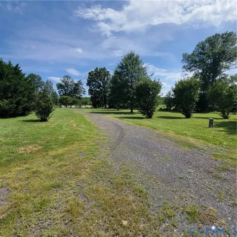 a view of a field with of trees in the background