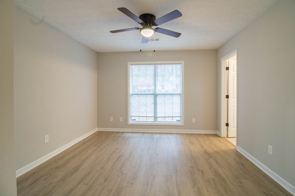 7001 Hunter Hill Court Columbus, GA 31907 - Photo 11 of 19 an empty room with wooden floor chandelier fan and windows