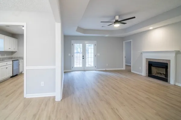 a view of an empty room with a fireplace and a window