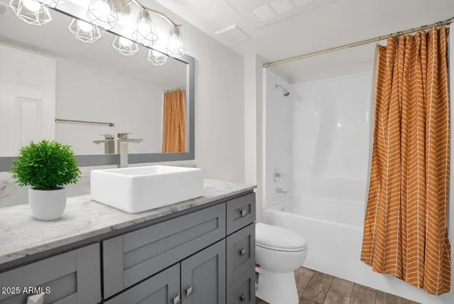 a bathroom with a granite countertop sink a toilet and shower