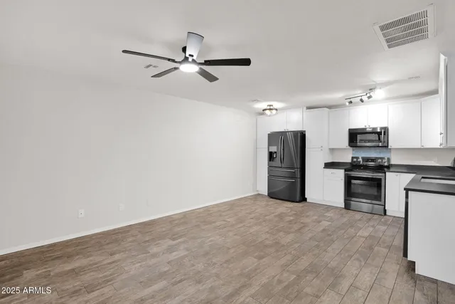 a view of a kitchen with a sink and a refrigerator
