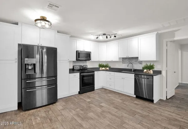 a kitchen with a refrigerator cabinets and stainless steel appliances