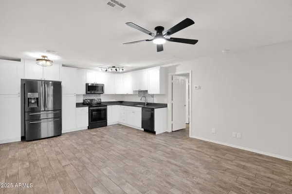 a kitchen with stainless steel appliances kitchen island granite countertop a refrigerator and a stove top oven