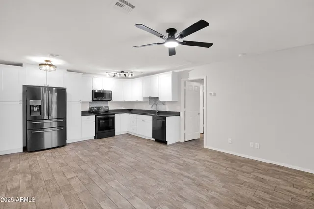 a kitchen with stainless steel appliances kitchen island granite countertop a refrigerator and a stove top oven