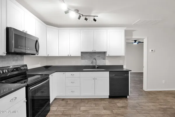 a kitchen with stainless steel appliances granite countertop a stove a sink and a microwave