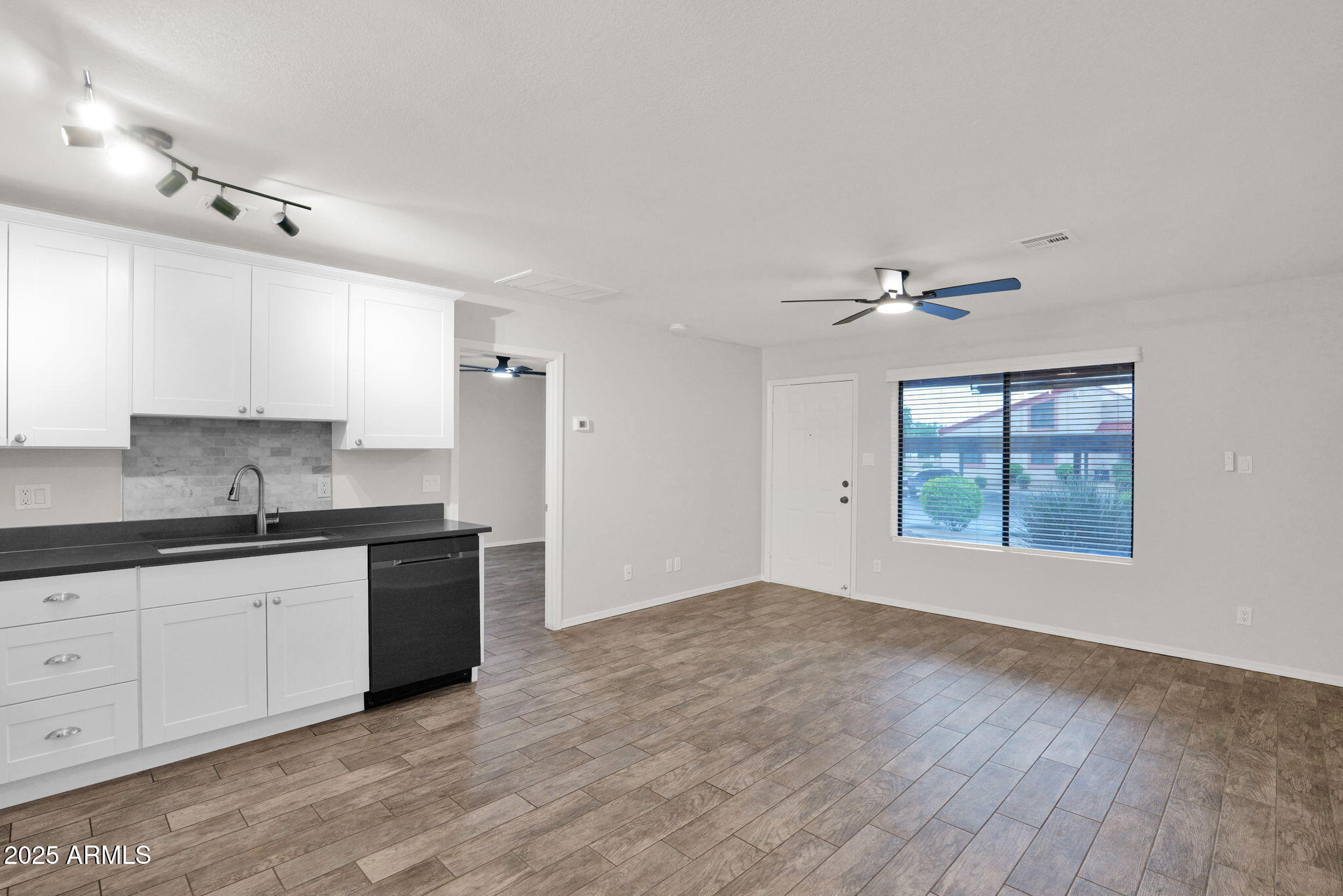 1440 North Idaho Road, Unit 1021 Apache Junction, AZ 85119 - Photo 9 of 24 a kitchen with granite countertop a stove a sink and white cabinets with wooden floor