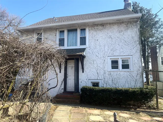 a front view of a house with plants