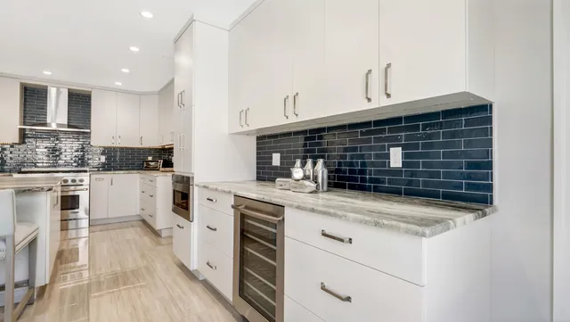 a kitchen with stainless steel appliances kitchen island granite countertop a table chairs sink and cabinets
