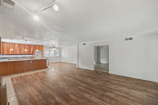 a kitchen with kitchen island granite countertop a sink a counter top space and cabinets