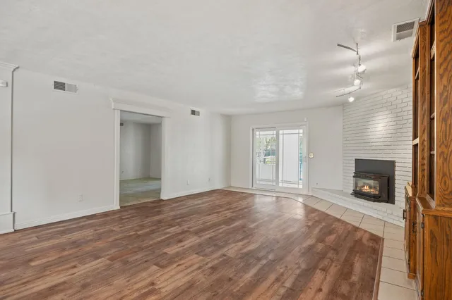 a view of an empty room with a window and fireplace