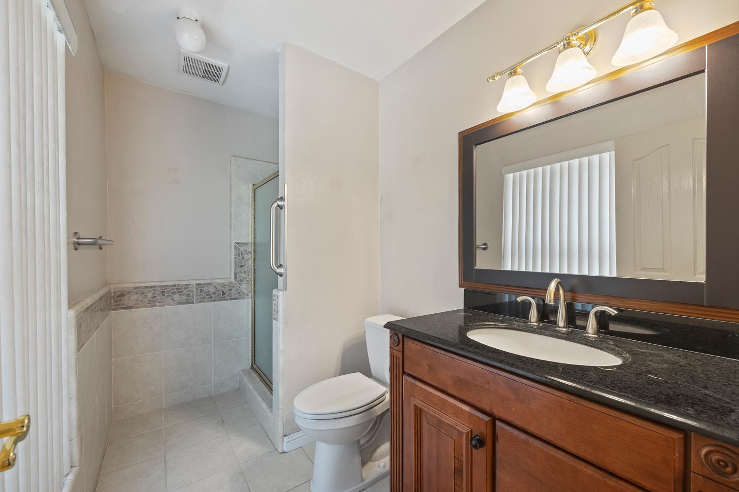 2179 Rall Avenue Clovis, CA 93611 - Photo 31 of 54 a bathroom with a granite countertop sink toilet and shower