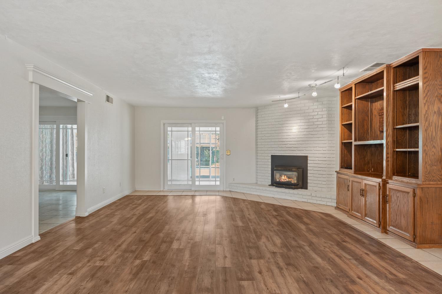 2179 Rall Avenue Clovis, CA 93611 - Photo 9 of 54 wooden floor fireplace and windows in an empty room