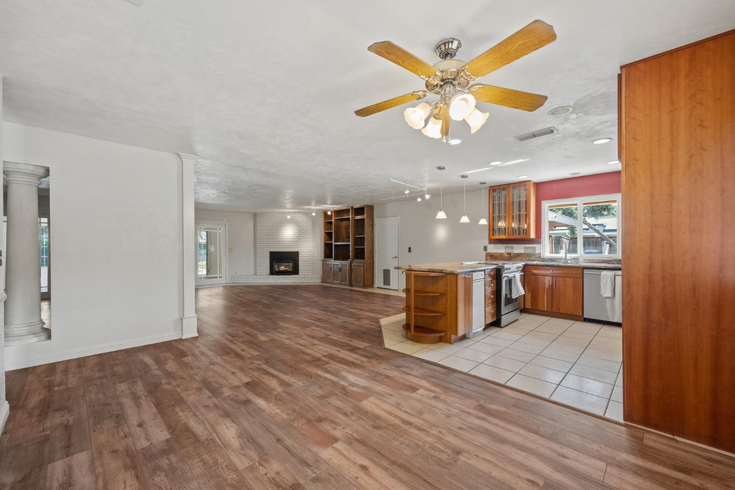2179 Rall Avenue Clovis, CA 93611 - Photo 10 of 54 an open kitchen with a sink dishwasher and a refrigerator with wooden floor