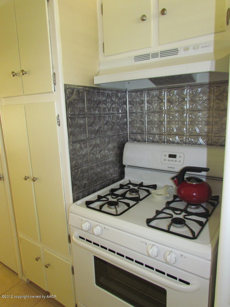 5313 Parker Street Amarillo, TX 79110 - Photo 13 of 26 a kitchen with a stove and a cabinet