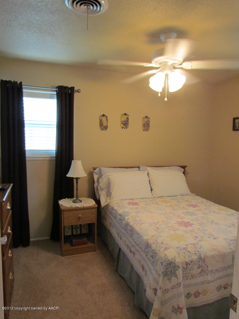 5313 Parker Street Amarillo, TX 79110 - Photo 16 of 26 a bedroom with a bed and a chandelier