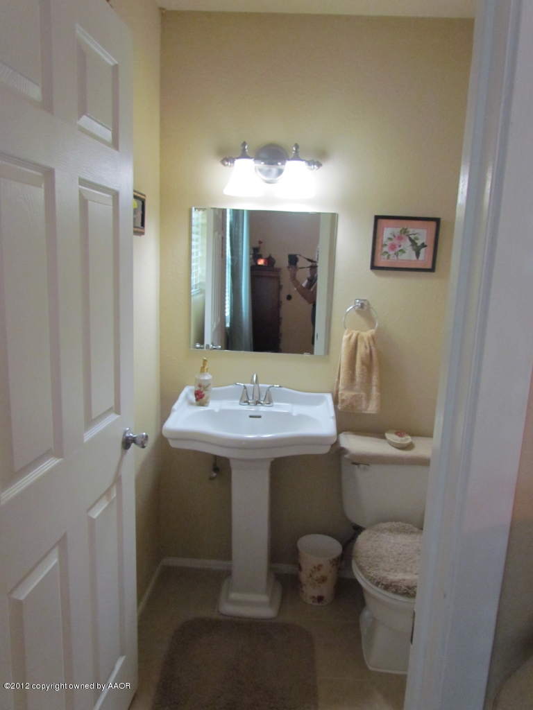 5313 Parker Street Amarillo, TX 79110 - Photo 19 of 26 a bathroom with a sink toilet and mirror