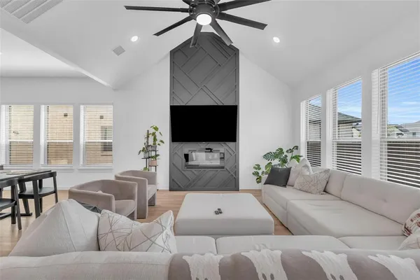 a living room with furniture a large window and a flat screen tv