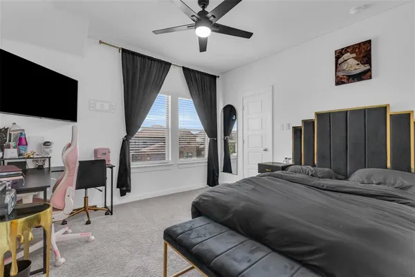 a bedroom with a bed a flat screen tv and a large window