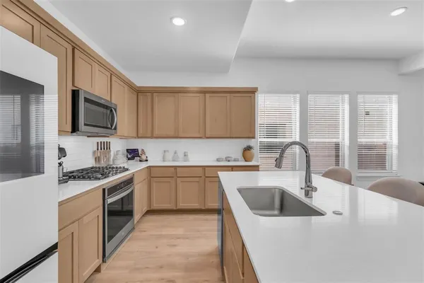 a kitchen with a sink a stove and cabinets