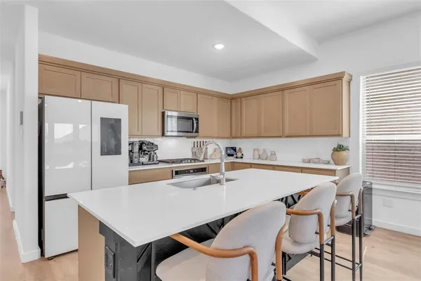 a kitchen with a table chairs refrigerator and cabinets
