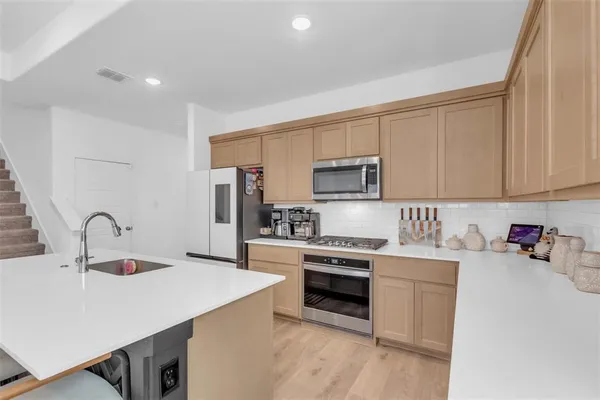 a kitchen with a sink cabinets and stainless steel appliances