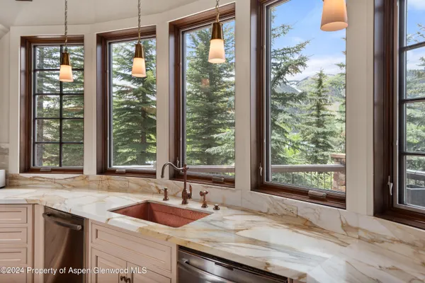 a kitchen with granite countertop sink and natural light