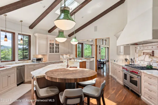 a view of a dining room with furniture a chandelier and wooden floor