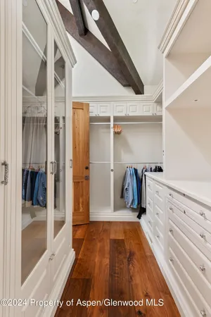 a view of walk in closet with clothes and shoes